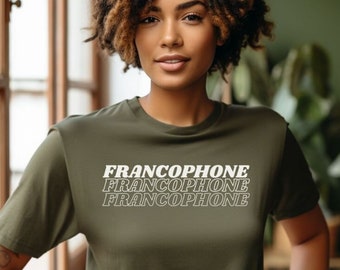 Op de afbeelding: Een vrouw draagt een groen T-shirt met het woord "Francophone" drie keer herhaald in witte tekst.