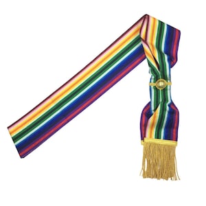 Puede incluir: Una banda de rayas de colores con una borla dorada y un botón dorado. La banda está hecha de satén y tiene un patrón de arcoíris.