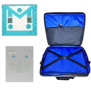 Puede incluir: Un delantal masónico blanco con ribetes y flecos turquesa, un par de guantes blancos con símbolos masónicos turquesa y una maleta de transporte negra con interior azul.