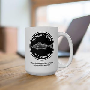 May include: White ceramic coffee mug with a black and white illustration of a walleye fish and the text "Walleye Anglers Anonymous" in a circle. The text "We've got problems, but we're not doing anything about it!" is printed below the circle.