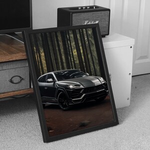 May include: A black Lamborghini Urus SUV parked in a forest setting. The car is facing the camera and the front grill and headlights are visible. The car is surrounded by tall trees.