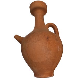 Puede incluir: Una jarra de terracota con cuerpo redondeado, cuello estrecho, borde ensanchado y un asa lateral. El recipiente presenta un pequeño pico inclinado que sobresale del hombro superior, mostrando una textura de arcilla natural, sin esmaltar.