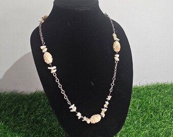 Carved bone design (plastic) with shell accents on a chain.