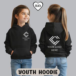 K&ouml;nnte beinhalten: Schwarzer Kinder-Hoodie mit Fronttasche und Kapuze. Auf der Vorder- und R&uuml;ckseite des Hoodies befinden sich ein wei&szlig;es Logo und der Text "YOUR LOGO HERE". Das Wort "BLACK" befindet sich in Herzform oben. Der Text "YOUTH HOODIE" steht unten.