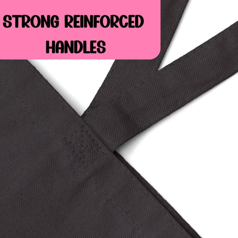 May include: Close-up of the reinforced handles of a black tote bag. The handles are stitched together with strong stitching.