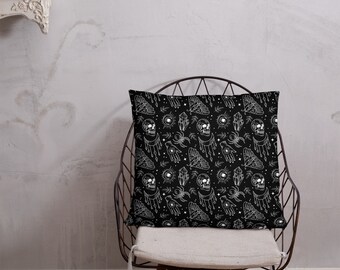 May include: Black throw pillow with a white design of skulls, crystals, moths, and hands. The design is repeated throughout the pillow.