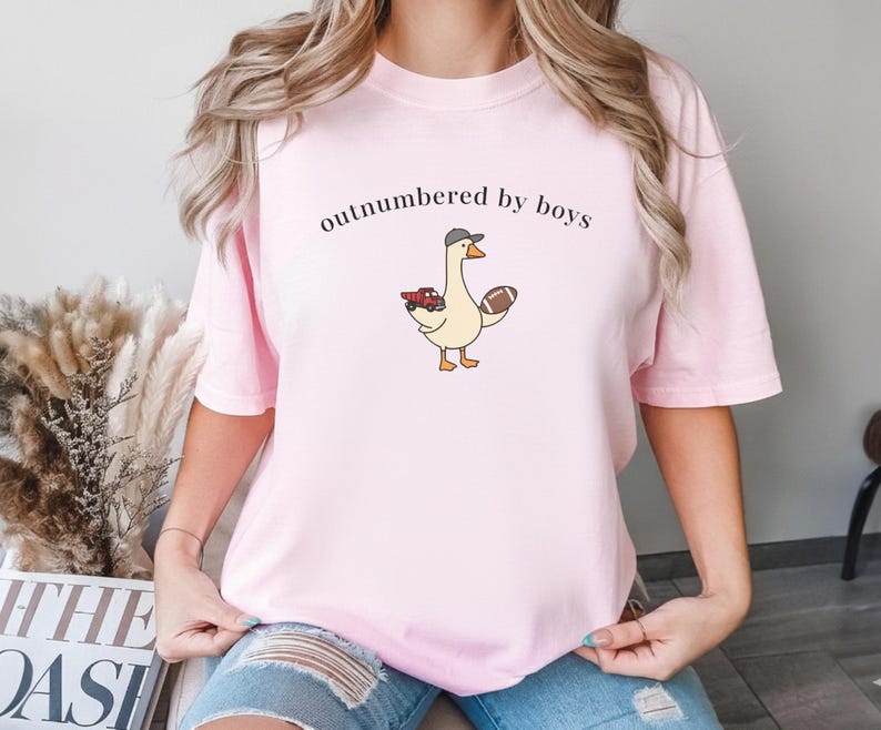 "Outnumbered by Boys Duck Sweatshirt, Funny Mom Shirt with Football and Truck Design, Personalized Family Apparel, Casual Gift for Mom" Outnumbered by boys, Funny mom sweatshirt, Personalized family tee, Duck graphic shirt, Football mom shirt, Truck design sweatshirt, Family gift idea, Mom shirt with kids, Cute mom sweater, Family matching shir, Casual mom outfit, Custom mom apparel, Funny family sweatshirt,
