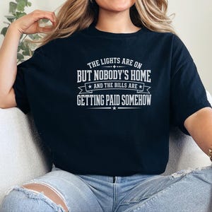 Funny Adult Humor Shirt, Sarcastic Adulting Tee, The Lights Are On But Nobody's Home and Bills Are Getting Paid Somehow, Gen X Gift image 3