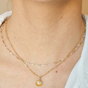 Collier multi-rangs fait main chaine plaqué or et perles de rocaille blanches et dorées. Photo portée.