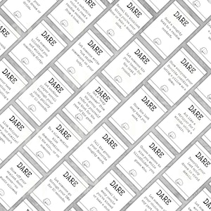 Op de afbeelding: Een verzameling witte kaarten met zwarte tekst, elk met het label "DARE" en met verschillende prompts. De kaarten zijn gerangschikt in een rasterpatroon, wat wijst op een spel of activiteit met uitdagingen en instructies.