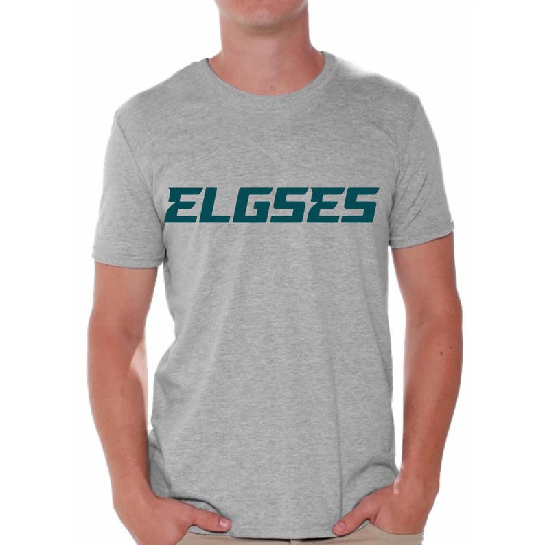 Op de afbeelding: Een grijs T-shirt met het woord "ELGSES" in tealblauw gedrukt.