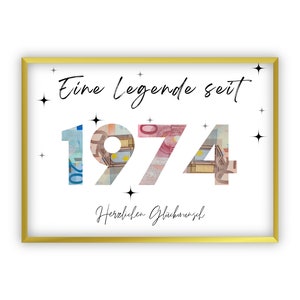 May include: A gold framed print with the text "Eine Legende seit 1974" in black script. The year 1974 is made of euro bills. The text "Herzlichen Glückwunsch" is below the year.