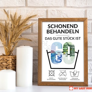 May include: A white framed print with the text "Schonend Behandeln Das Gute St&uuml;ck Ist 60" in black. The number 60 is made of euro bills. Below the text are three laundry care symbols: "Nicht Schleudern", "Falten Nicht B&uuml;gelbar", and "T&auml;gliche Handw&auml;sche".