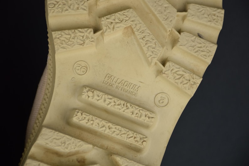 Puede incluir: Primer plano de la suela de un zapato beige con suela texturizada. El zapato est&aacute; etiquetado como "Palladium Made in France" y tiene la talla 36 impresa.