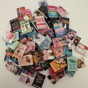 May include: A pile of paperback books with various titles and authors. The books are mostly romance novels with colourful covers. Some of the titles include "Wild Love", "The Date", "Awake at Dawn", "Hopeless", and "New Year's Day".