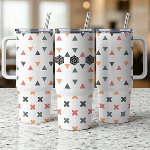 May include: Three white travel mugs with lids, handles, and straws. The mugs feature repeating patterns of orange, green, and pink triangles, black geometric shapes, and orange and pink cross-like designs.