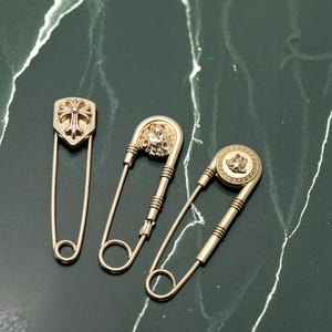 ゴールドの安全ピンブローチ、十字架、ライオン、紋章デザインの高級装飾ピン - ジャケット用のゴシック美的パンクブローチピン