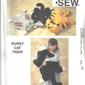 May include: Kwik Sew pattern 2339 for animal pillows. The image shows a bunny, cat, and tiger pillow pattern. The cat pillow is black with white and pink accents. The tiger pillow is orange with black stripes.