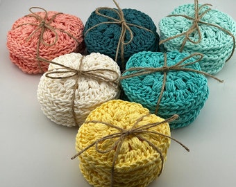 May include: Six crocheted cotton rounds in various colors, including teal, white, yellow, and pink. The rounds are tied together with twine.