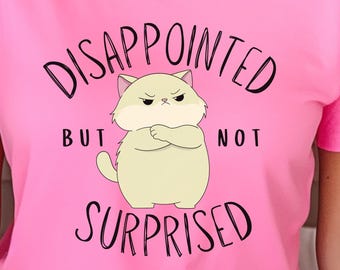 May include: Pink t-shirt featuring a cartoon cat and the text "DISAPPOINTED BUT NOT SURPRISED".