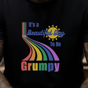 May include: A black t-shirt with a rainbow design and the text "It's a Beautiful Day To Be Grumpy".