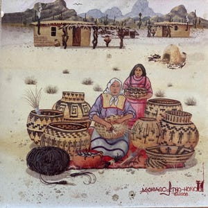 May include: Two women are sitting on the ground weaving baskets. The women are wearing traditional clothing and are surrounded by baskets of various sizes and designs. The scene is set in a desert landscape with a few buildings in the background. The text "Mshiago Tho-Honoh 2008" is visible in the bottom right corner.