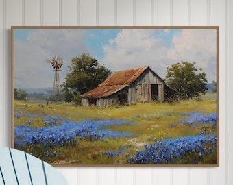 May include: A light blue wooden rocking chair sits next to a table lamp with a light blue base and a beige shade. Above the chair, a framed landscape painting depicts a rustic barn, a windmill, and a field of blue flowers under a sky.