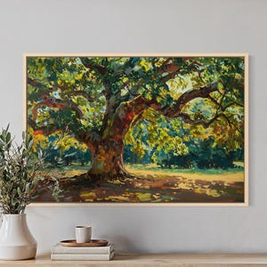 May include: A rectangular landscape painting in a light wood frame depicting a large, mature tree with thick, textured branches and dense green and yellow foliage. The scene features dappled sunlight casting shadows on the ground beneath the tree.