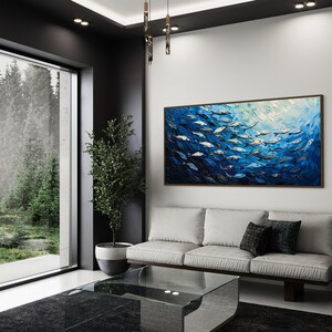 A dynamic school of fish swims in unison through the tranquil blue sea, their silvery scales reflecting light, depicted with thick, textured brushstrokes that give life and movement to this captivating marine scene.