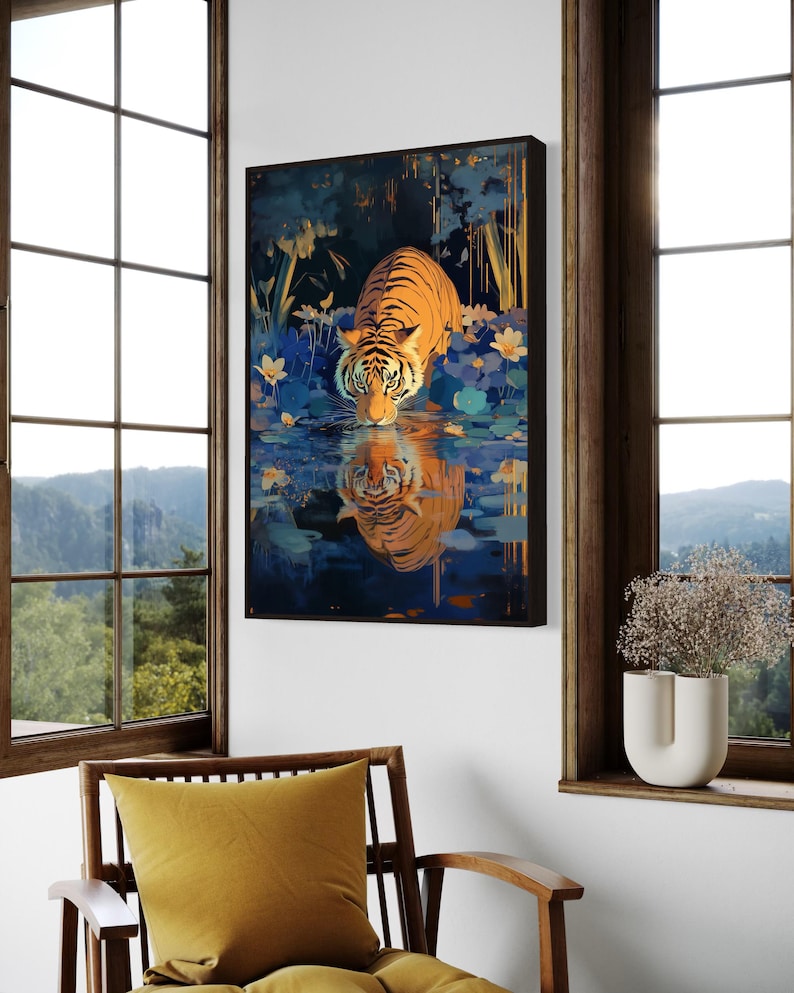 A majestic tiger drinks from a calm lake, its reflection glowing in golden hues. Surrounded by blue flowers and soft light, this art print blends nature with elegance, perfect for boho, nature, or wildlife-themed home decor.