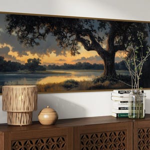 Capturing the tranquil essence of dusk, this panoramic artwork features a majestic oak tree overlooking a serene river, illuminated by the golden hues of a setting sun.