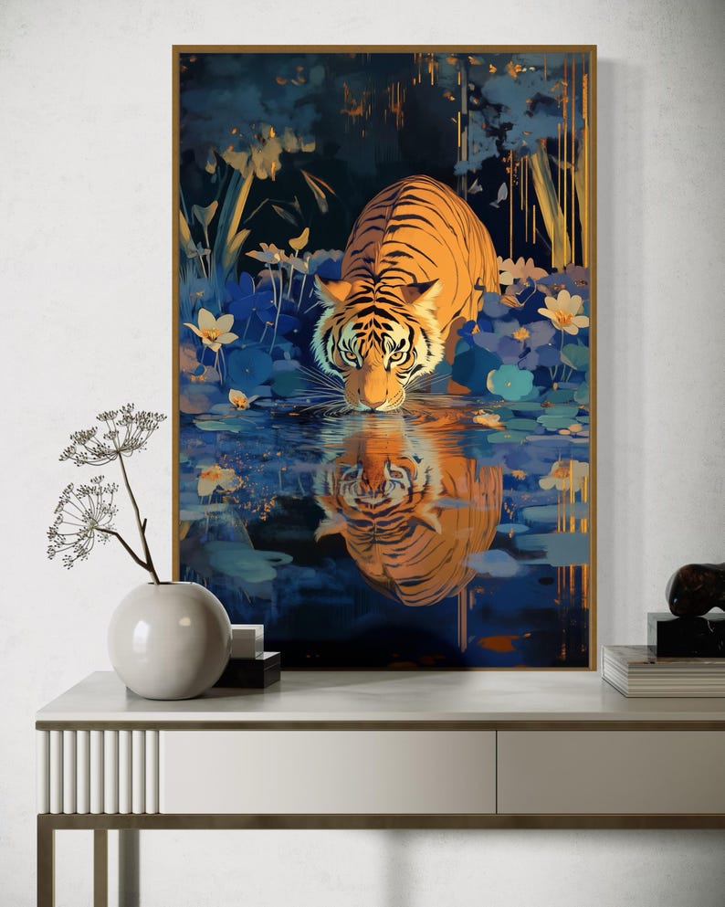 A majestic tiger drinks from a calm lake, its reflection glowing in golden hues. Surrounded by blue flowers and soft light, this art print blends nature with elegance, perfect for boho, nature, or wildlife-themed home decor.