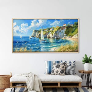 Sailboats glide on azure waters near chalky cliffs with green tops under a vast, cloud-dappled sky, portraying a serene, sunlit seascape.