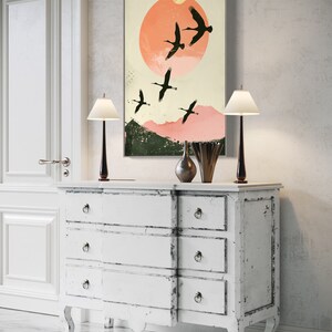 Silhouettes in Flight: A serene composition featuring cranes soaring across a textured pink sunset, their graceful forms framed against a full moon.