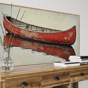 This artwork features a rustic red canoe resting serenely on calm waters. The canoe, with its weathered surface, reflects beautifully in the water, showcasing its rich color. The soft background adds a tranquil atmosphere, perfect for nature lovers.
