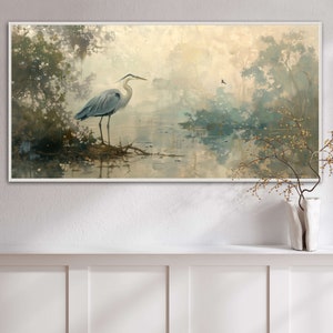 A serene heron stands amidst a tranquil swamp, reflected in the calm waters, set against a backdrop of ethereal, golden-hued trees and a soft, diffuse light that permeates this peaceful landscape painting.