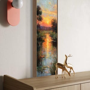 Impressionist landscape art of a glowing sunset over a peaceful waterway with lily pads and tall grasses. The golden light reflects on the calm water, surrounded by soft trees and vibrant colors. A serene nature scene perfect for rustic, cottage, or lake house decor.
