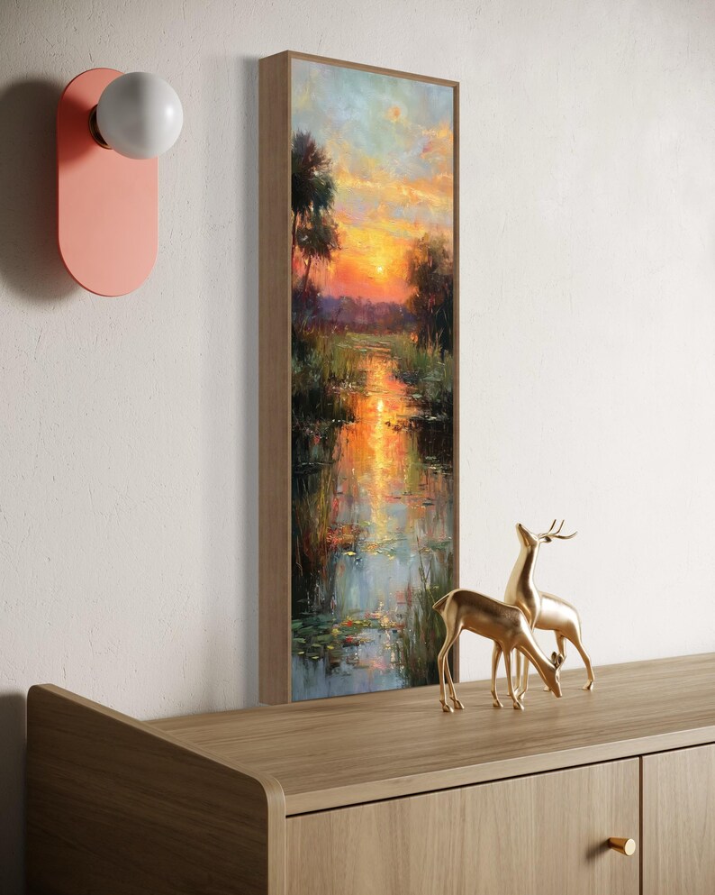 Impressionist landscape art of a glowing sunset over a peaceful waterway with lily pads and tall grasses. The golden light reflects on the calm water, surrounded by soft trees and vibrant colors. A serene nature scene perfect for rustic, cottage, or lake house decor.
