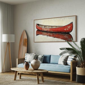 This artwork features a rustic red canoe resting serenely on calm waters. The canoe, with its weathered surface, reflects beautifully in the water, showcasing its rich color. The soft background adds a tranquil atmosphere, perfect for nature lovers.