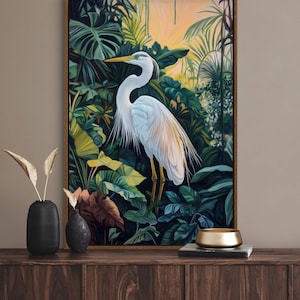 This canvas print captures a majestic heron standing amidst lush tropical foliage, illuminated by a soft, golden sunrise. Its detailed portrayal and vibrant setting make it a striking piece for any nature or bird enthusiast's collection.