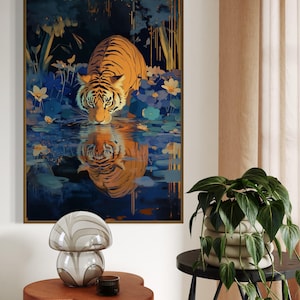 A majestic tiger drinks from a calm lake, its reflection glowing in golden hues. Surrounded by blue flowers and soft light, this art print blends nature with elegance, perfect for boho, nature, or wildlife-themed home decor.