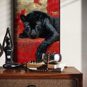 Striking art print of a black panther resting against a rich red and gold abstract background. The panther’s piercing gaze, sleek dark fur, and powerful presence create a dramatic and luxurious statement piece, blending wildlife majesty with bold modern art design for a captivating interior accent.