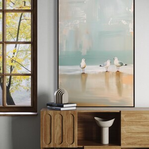 Serene Shoreline Trio: Three seagulls stand in quiet contemplation, their crisp white feathers a calm contrast to the creamy shoreline backdrop.