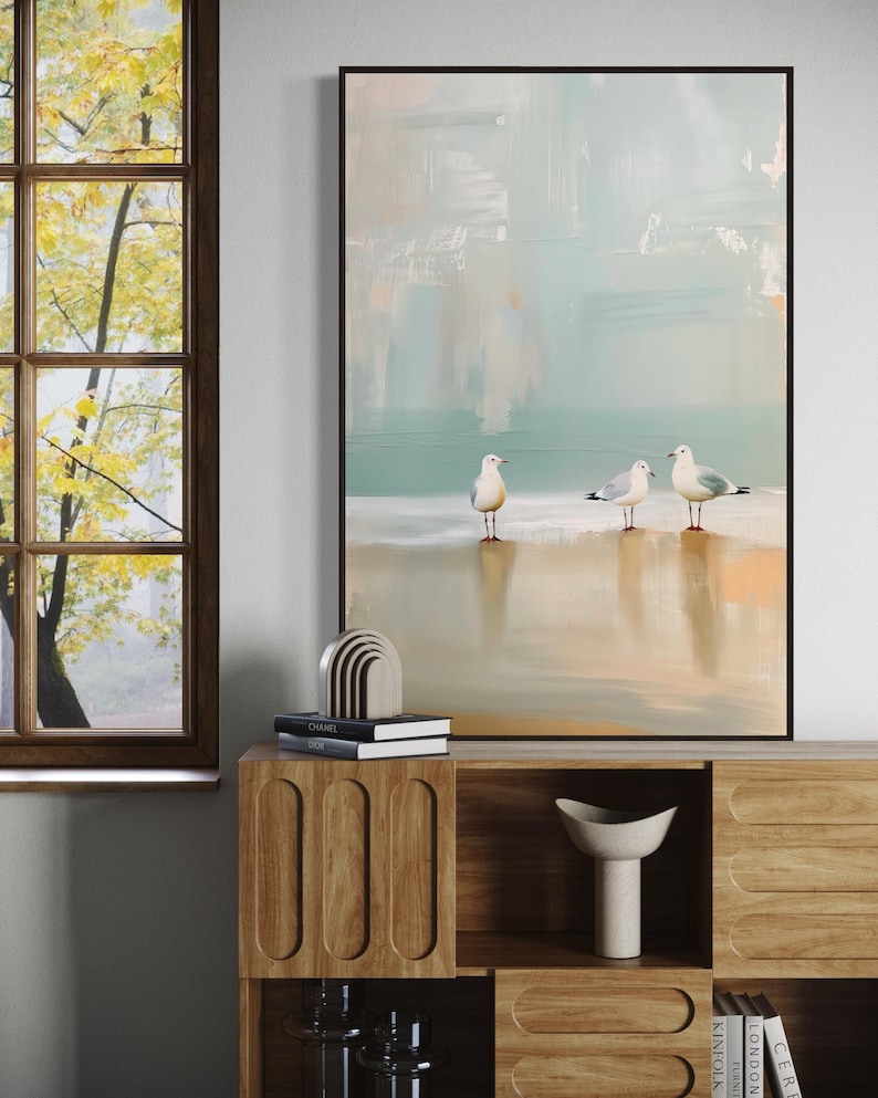 Serene Shoreline Trio: Three seagulls stand in quiet contemplation, their crisp white feathers a calm contrast to the creamy shoreline backdrop.