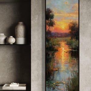 Impressionist landscape art of a glowing sunset over a peaceful waterway with lily pads and tall grasses. The golden light reflects on the calm water, surrounded by soft trees and vibrant colors. A serene nature scene perfect for rustic, cottage, or lake house decor.