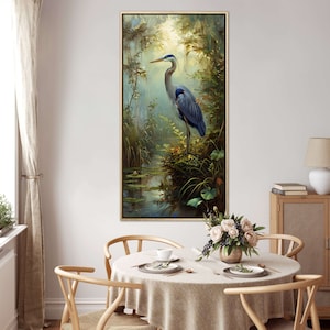 A serene Blue Heron stands amidst a lush wetland oasis, its graceful form bathed in dappled sunlight filtering through a verdant canopy. Perfect for a tranquil decor piece.