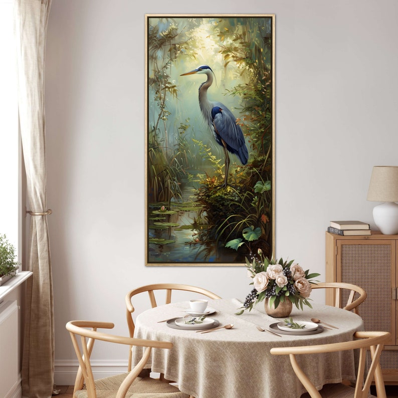 A serene Blue Heron stands amidst a lush wetland oasis, its graceful form bathed in dappled sunlight filtering through a verdant canopy. Perfect for a tranquil decor piece.