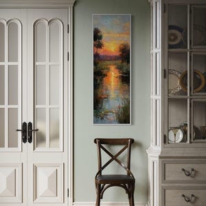 Impressionist landscape art of a glowing sunset over a peaceful waterway with lily pads and tall grasses. The golden light reflects on the calm water, surrounded by soft trees and vibrant colors. A serene nature scene perfect for rustic, cottage, or lake house decor.