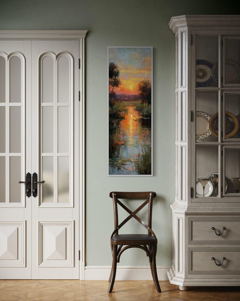 Impressionist landscape art of a glowing sunset over a peaceful waterway with lily pads and tall grasses. The golden light reflects on the calm water, surrounded by soft trees and vibrant colors. A serene nature scene perfect for rustic, cottage, or lake house decor.