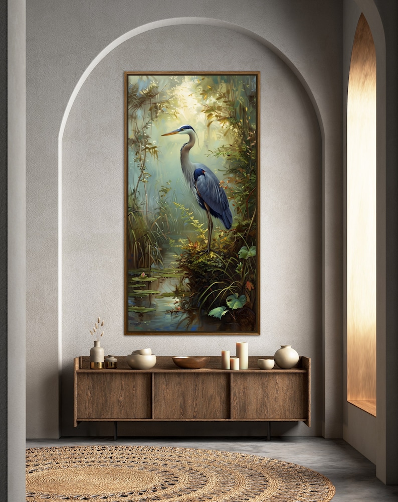 A serene Blue Heron stands amidst a lush wetland oasis, its graceful form bathed in dappled sunlight filtering through a verdant canopy. Perfect for a tranquil decor piece.